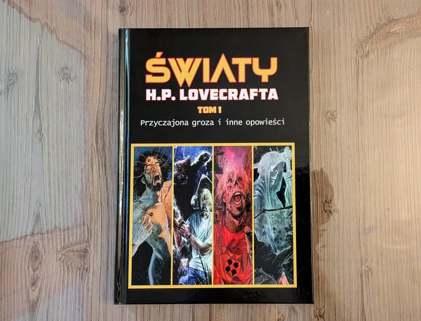 Komiks „Światy H. P. Lovecrafta. Tom 1" leżący na drewnianym stole